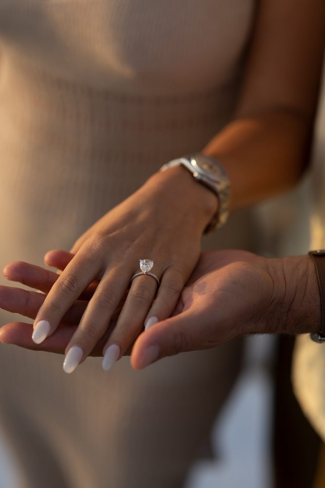 A close-up of the engagement ring on her hand in the evening light