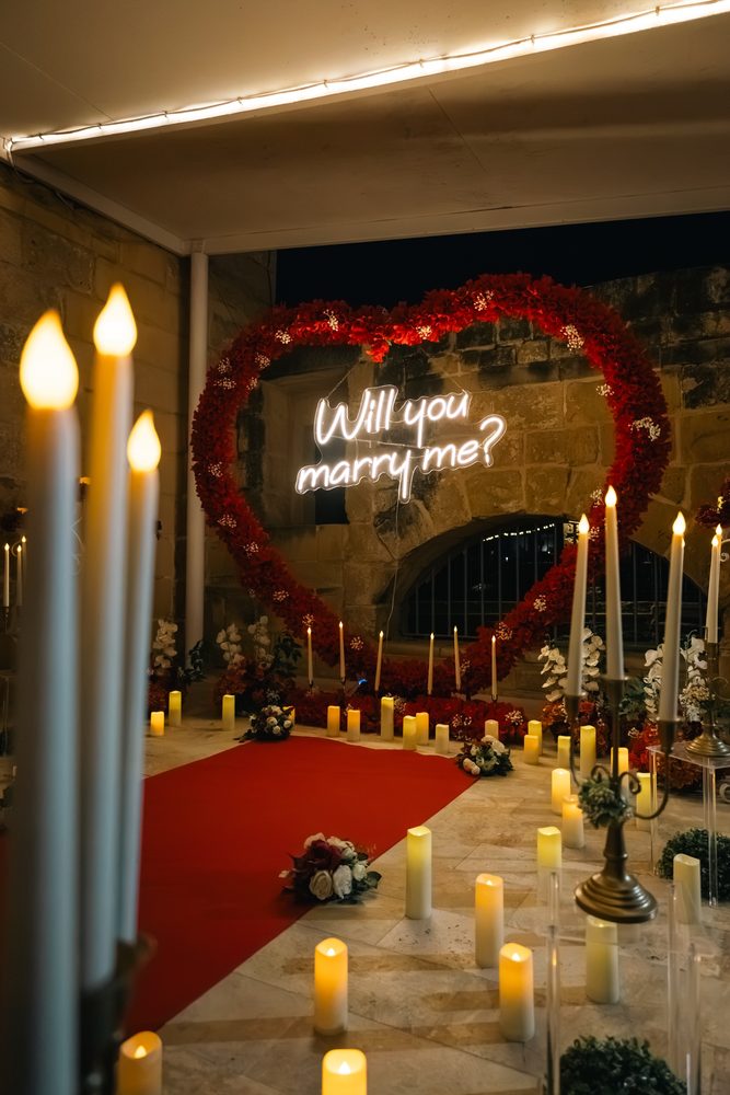 The red rose heart and neon sign against an old stone archway